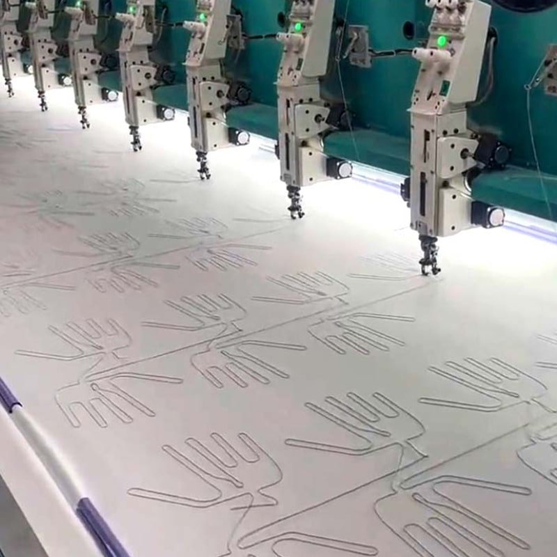 automated production of carbon fiber heating elements for washable heated clothing and heated apparel manufacturing