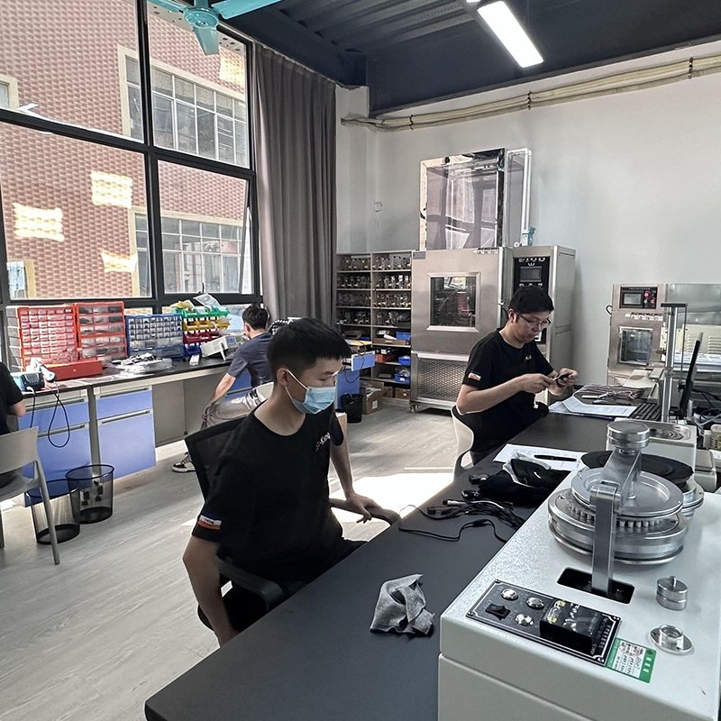 engineers testing heated gloves and battery packs in laboratory OEM heated apparel R&D validation temperature control and product reliability testing