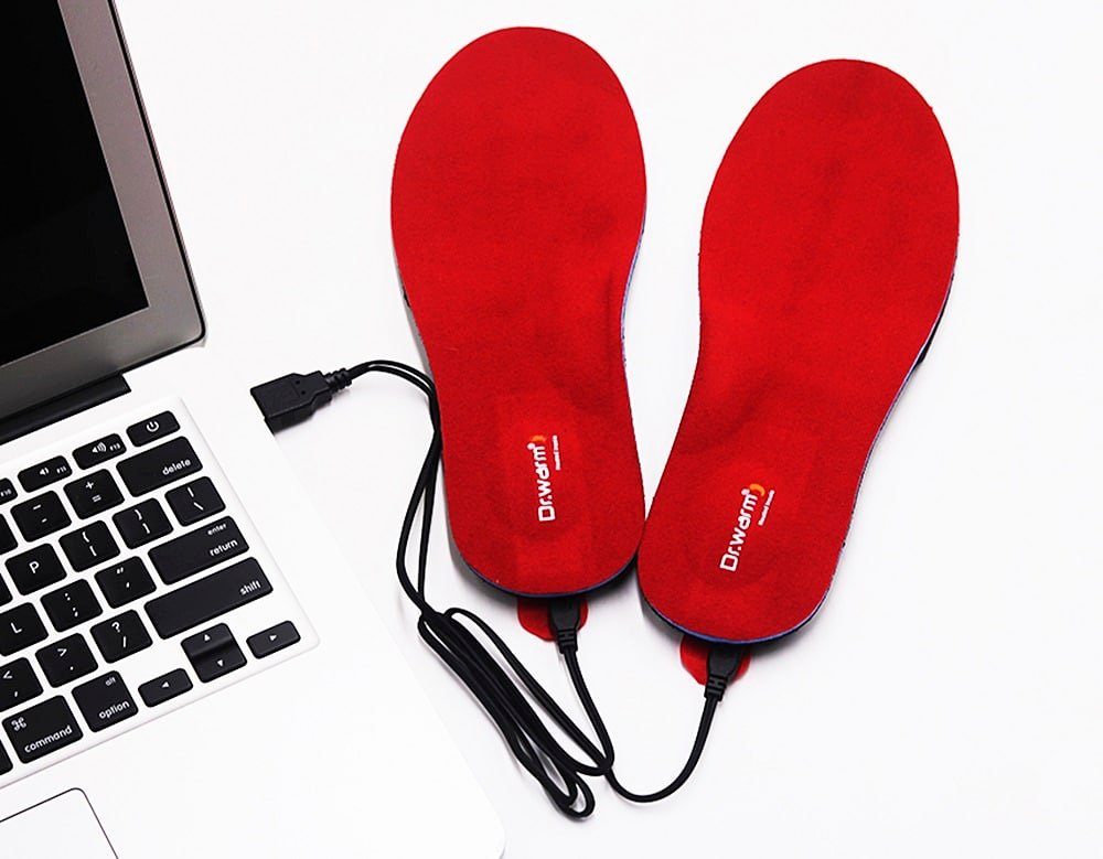 Dr.warm red USB powered heated insoles connected to power bank via USB cable, electric heated foot warmers for cold weather and winter comfort on laptop desk