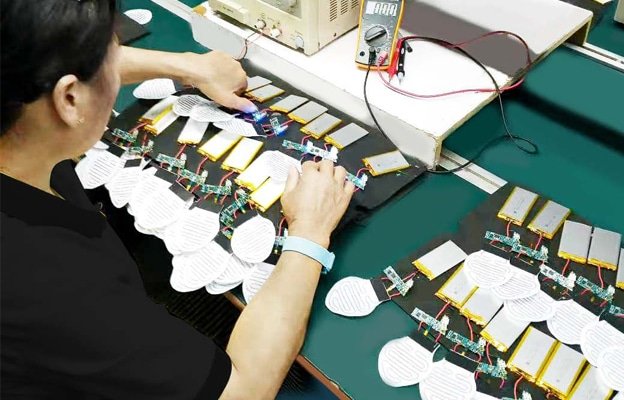 Factory engineers conducting heated apparel testing on batteries and heating elements to ensure safety, stable heating performance, and quality control before mass production.