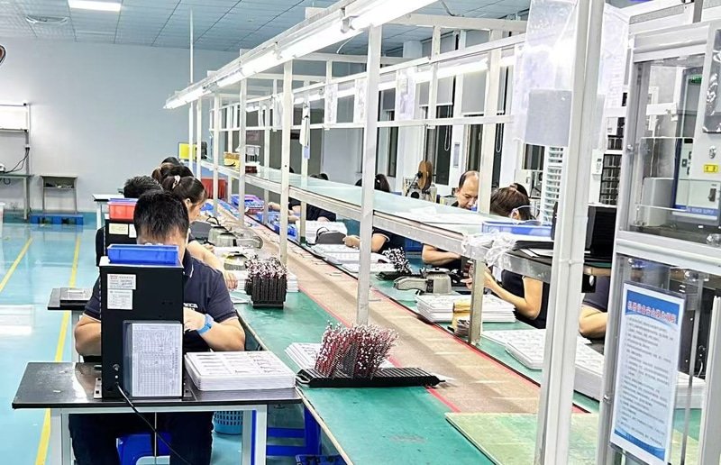 Inside a modern, clean factory workshop dedicated to producing heating elements for custom apparel, showing automated equipment and quality control stations.