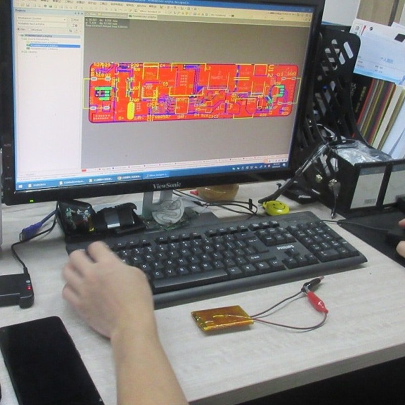 engineer designing custom PCBA layout for heated clothing controller and smart temperature control system for heated wearables