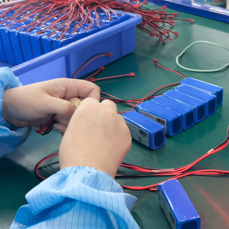 factory worker assembling lithium battery packs for heated apparel battery and heated clothing power supply