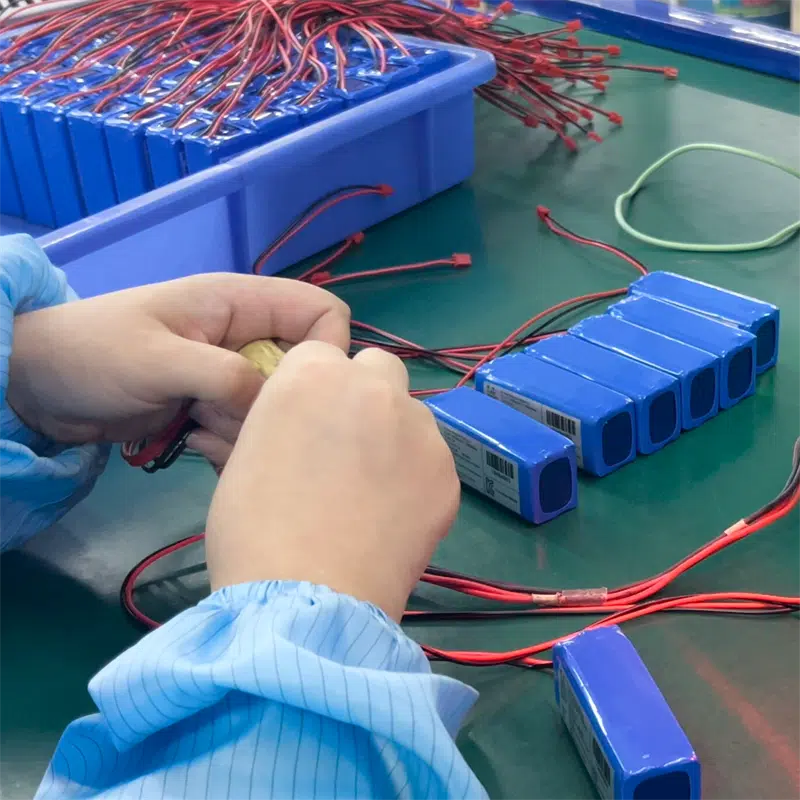 factory worker assembling lithium battery packs for heated apparel battery and heated clothing power supply
