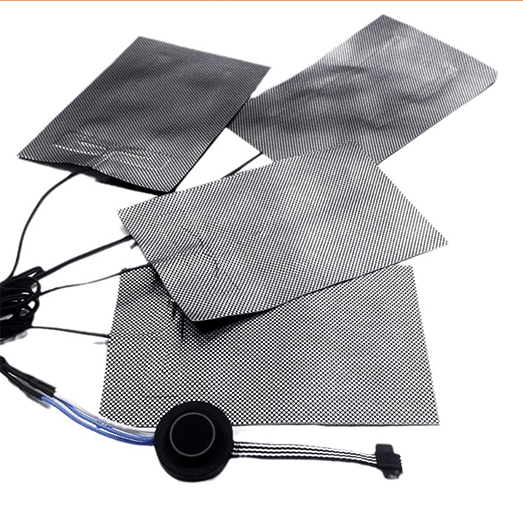 Multiple black graphene heating films with grid pattern texture, connected to circular control button and wiring harness, flexible carbon-based heating elements