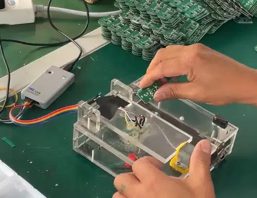 Engineer testing custom PCB controller boards for heated gloves at our factory